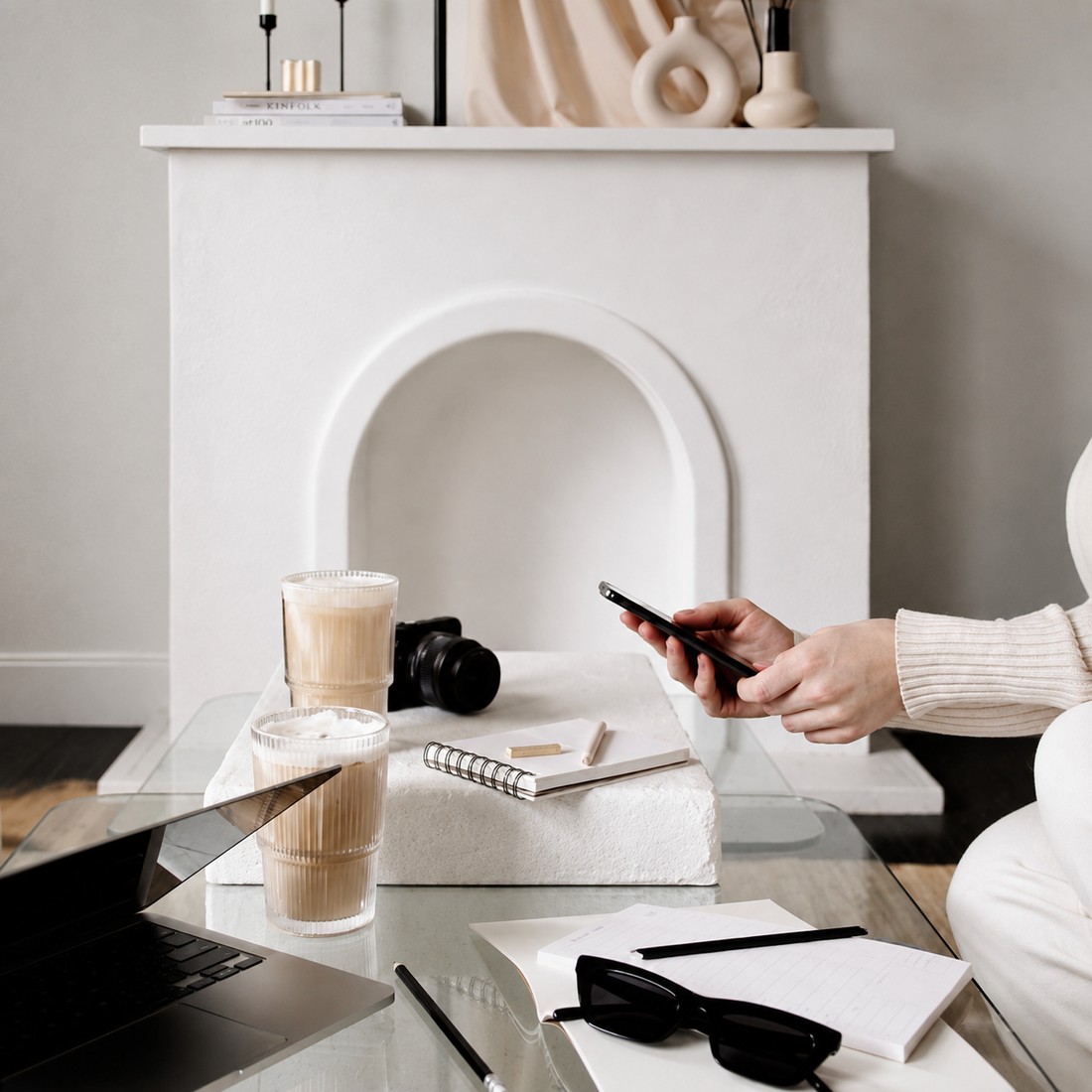 Flat lay workspace with a laptop, iced coffee, camera, and notebook, representing The Agency's design process
