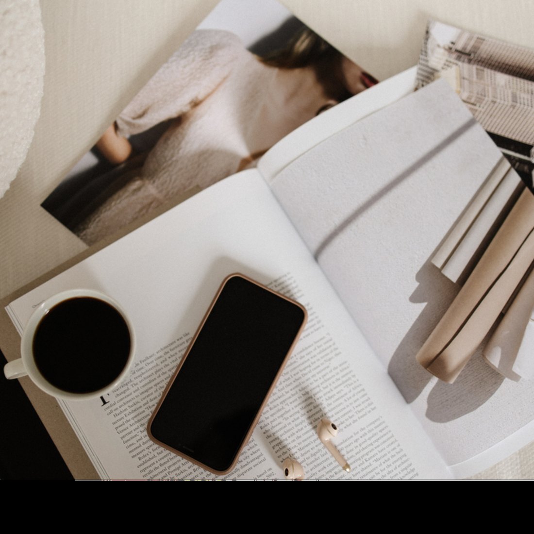 Editorial flat lay of open magazine, phone, and coffee showing the polished brand identity style The Agency creates for established businesses