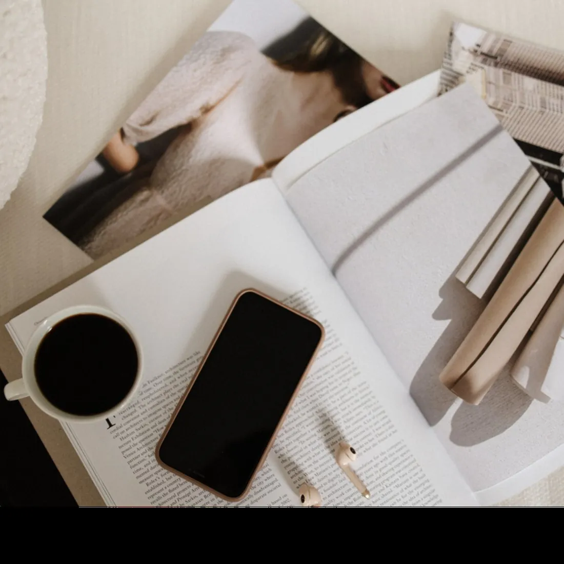 Editorial flat lay of open magazine, phone, and coffee showing the polished brand identity style The Agency creates for established businesses