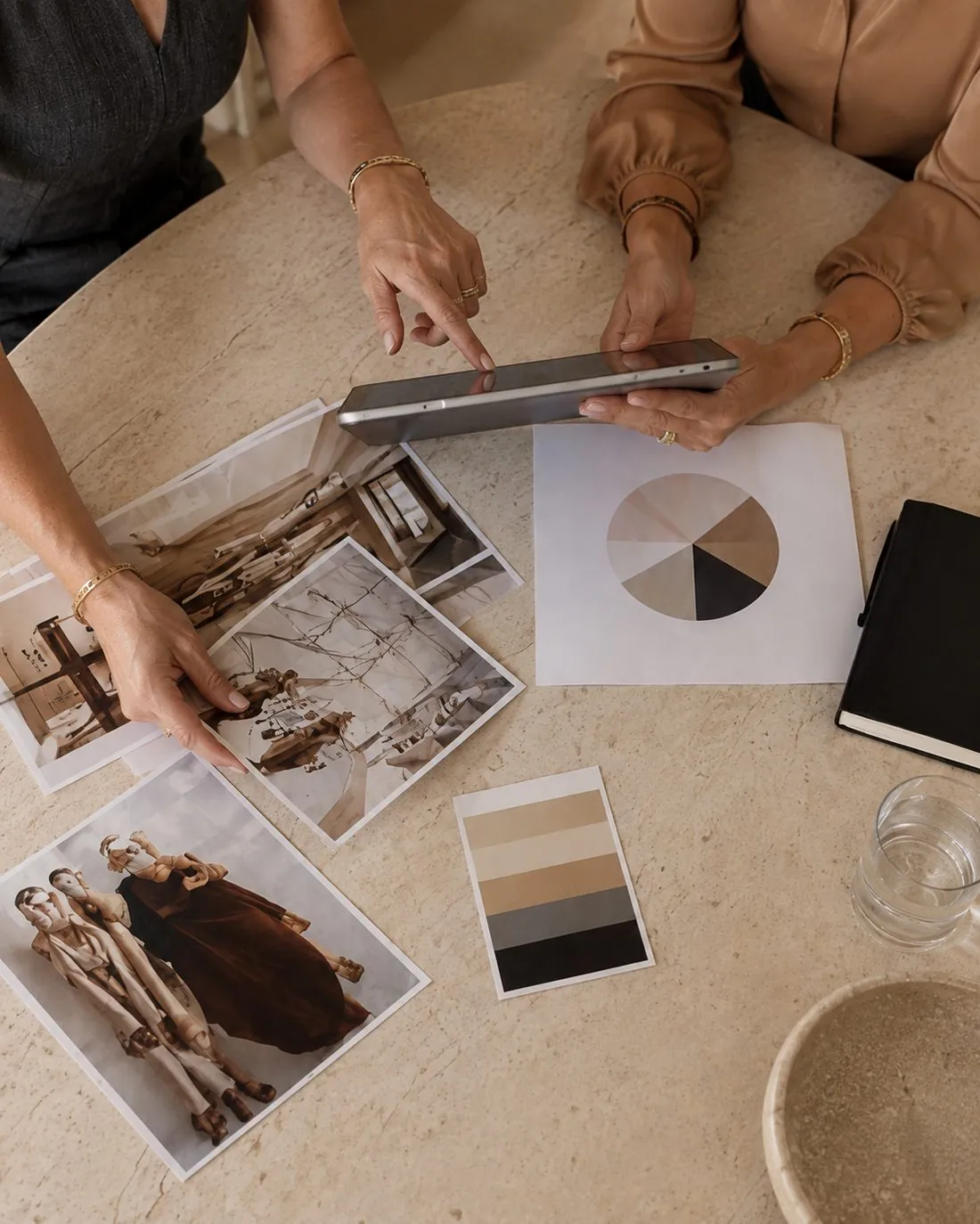 Two people reviewing campaign creative, a color palette and an audience chart on a tablet at The Agency