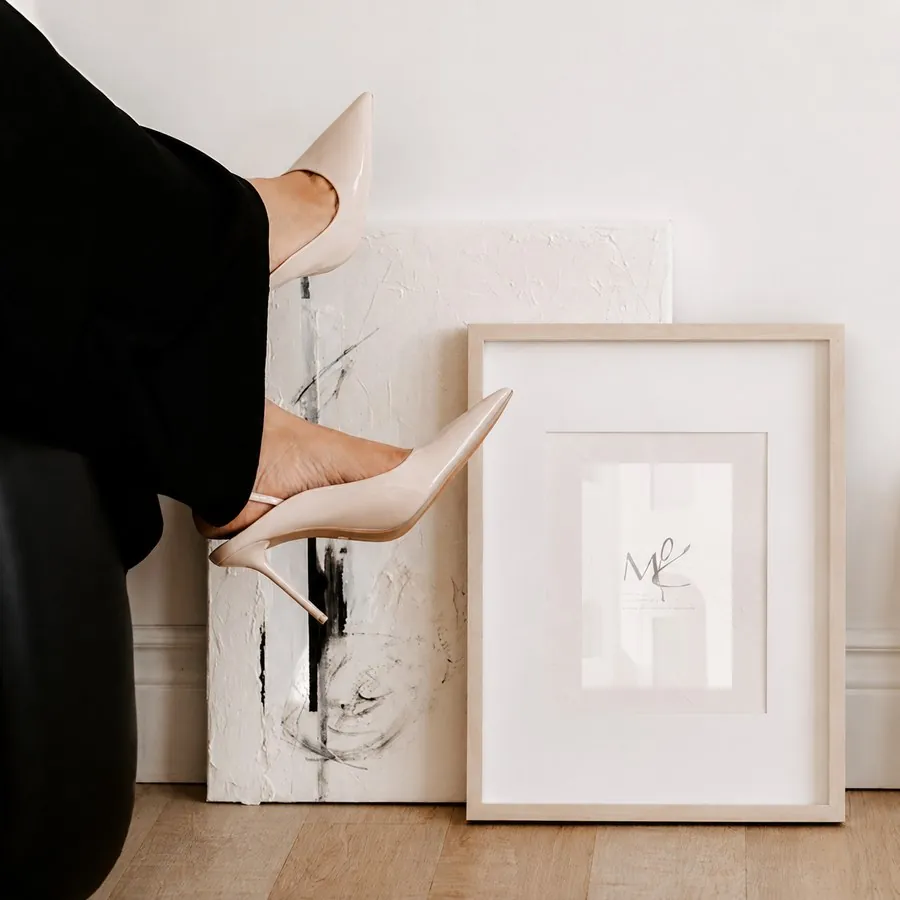 Editorial photo of nude heels beside framed artwork, accompanying a client testimonial about website design results from The Agency