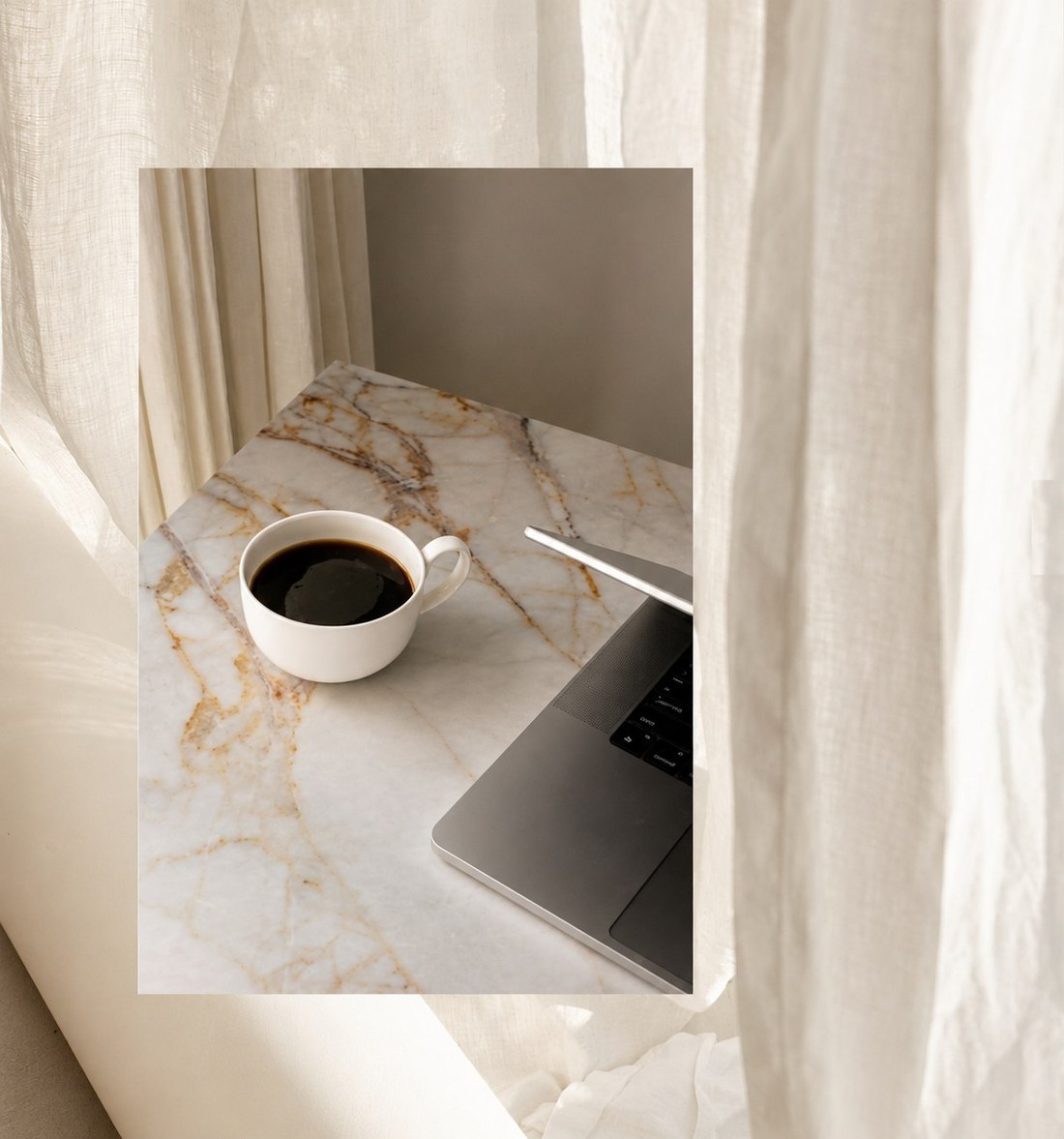 Coffee and laptop on a marble table at The Agency studio in Sioux Falls