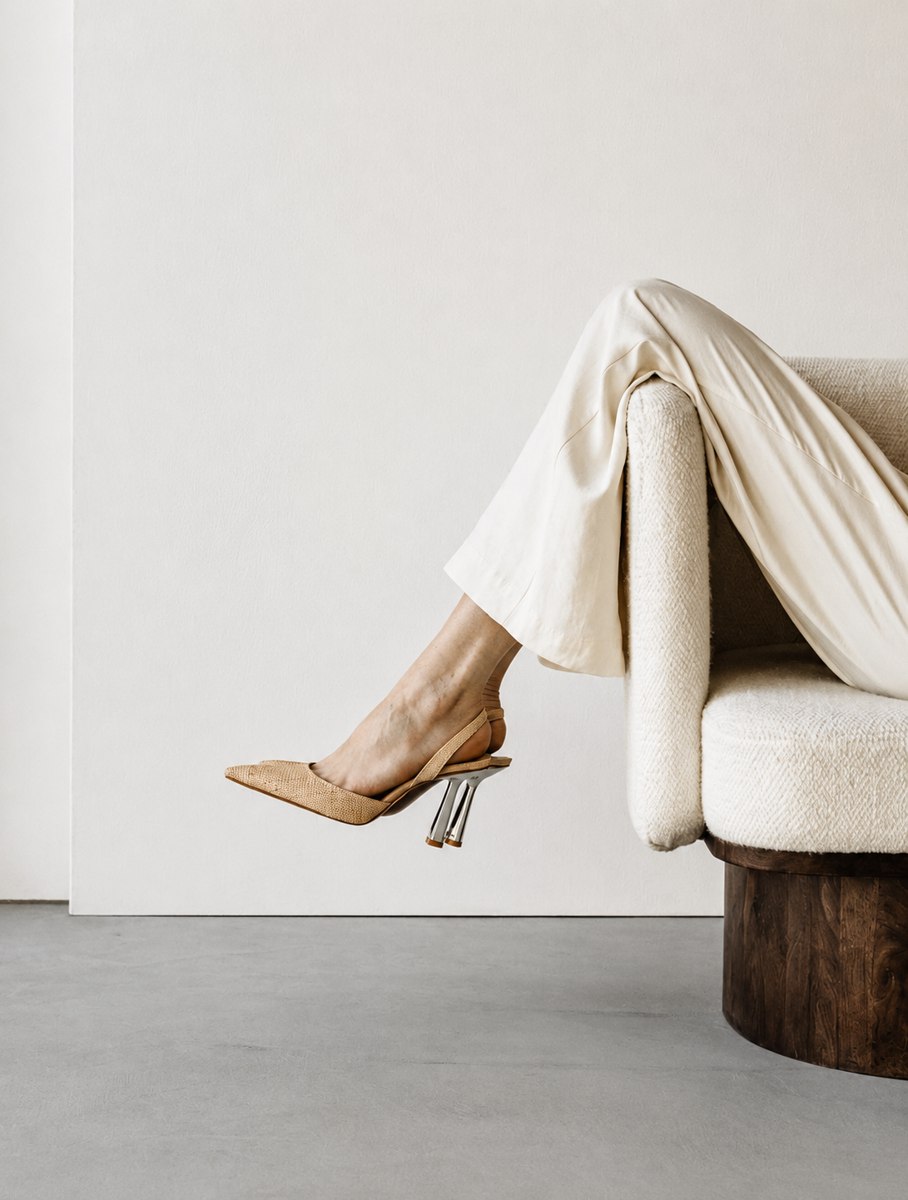 Nude slingback heel over the arm of a boucle chair, styling for The Agency's list of what's included