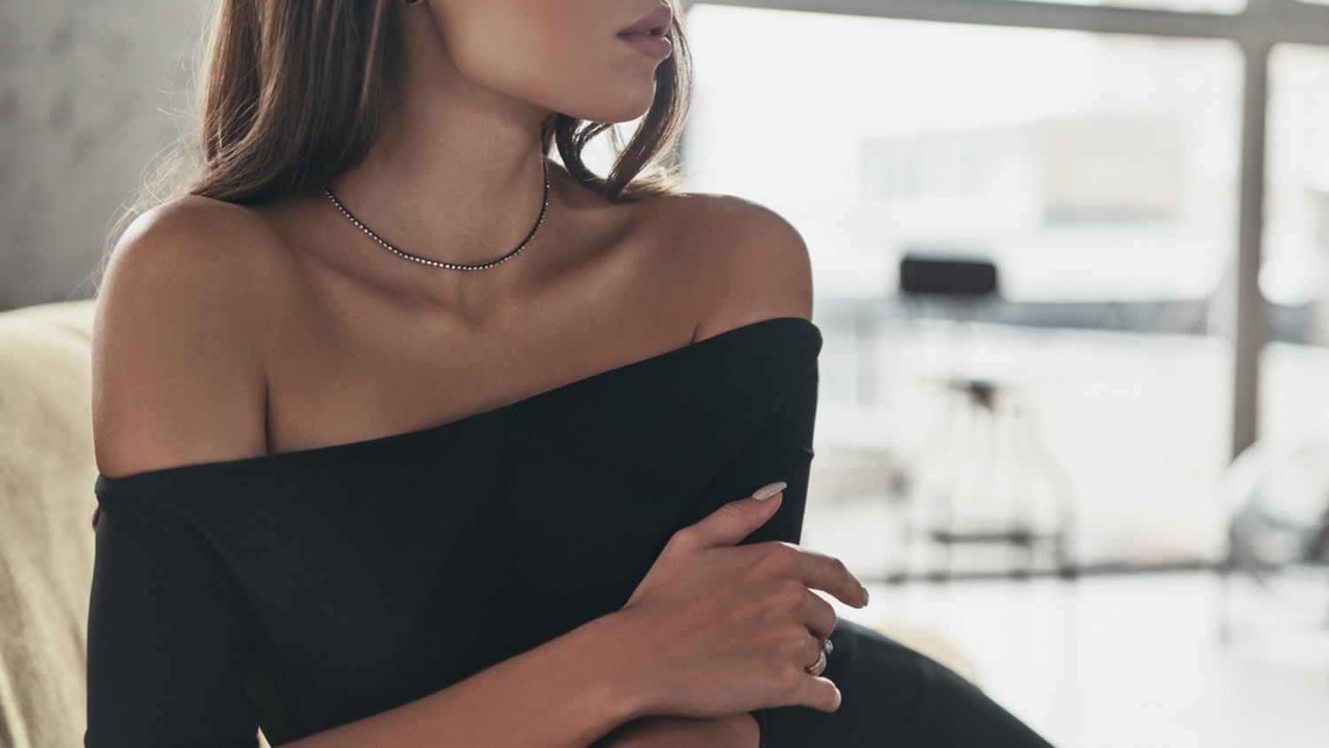 Confident woman in an elegant black top, inviting established business owners to download The Agency's free strategic guide